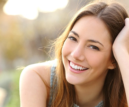 Woman with brown hair smiling outside